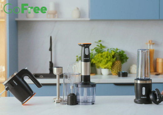 Mikser, blender ręczny wraz z akcesoriami i blender kielichowy na kuchennym blacie.