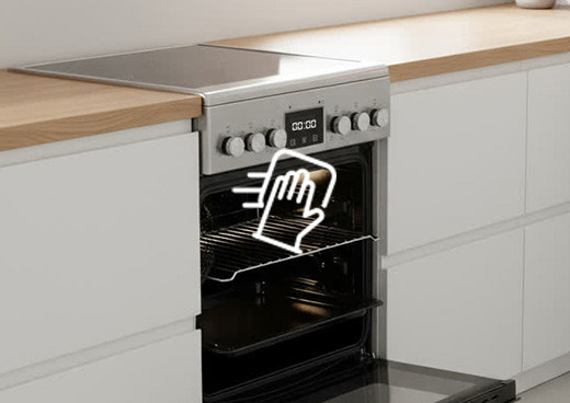 Otwarty piekarnik  kuchenki  elektrycznej  z płytą ceramiczną MPM-55-KEC-40. Na piekarniki symbol ręki i ściereczki.